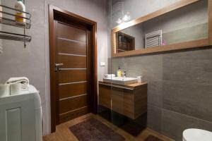 a bathroom with a sink and a toilet and a mirror at VIP Apartamenty Białystok in Białystok