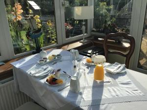 uma mesa com uma toalha de mesa branca com comida em The Haven B&B em Castle Douglas