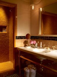 a bathroom with a sink and a mirror and a shower at The Greenwich Hotel in New York