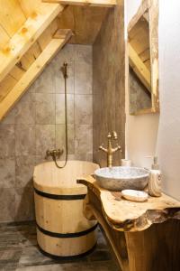 a bathroom with a wooden barrel sink and a tub at Casa Bunicilor Apuseni in Geogel +30 photos