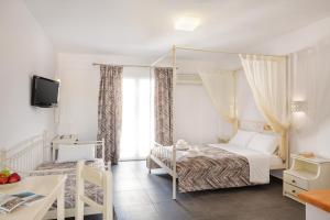 a bedroom with a large bed and a large window at Sea View Beach Hotel in Perivolos
