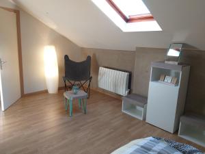 a attic room with a chair and a heater at Le Manant in Bellegarde-sur-Valserine