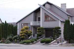 a house with trees and bushes in front of it at Alma B&B in Kalvarija