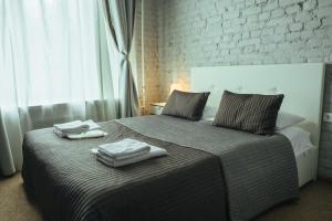 a bedroom with a bed with two towels on it at Geleon in Saint Petersburg