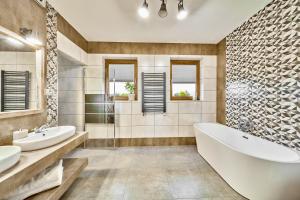 uma casa de banho com 2 lavatórios, uma banheira e um chuveiro em Apartament Turbacz em Klikuszowa