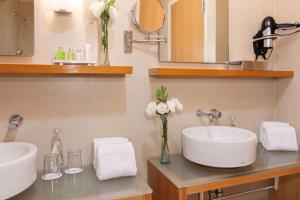 a bathroom with two sinks and two mirrors at NH Queretaro in Querétaro