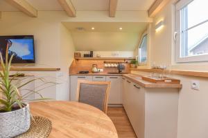 a kitchen with a table and a tv in a room at "Pamario Namelis" - Preiloje in Neringa