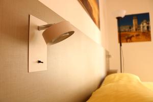 una camera da letto con un letto con una luce sul muro di Appartamento Picasso a Bergamo