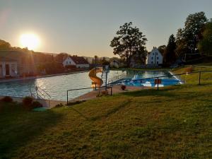 una piscina con un tobogán frente al agua en Ferienwohnung Erzgebirge, en Grünhainichen