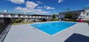 a swimming pool in front of a building at Grand Forks Inn in Grand Forks