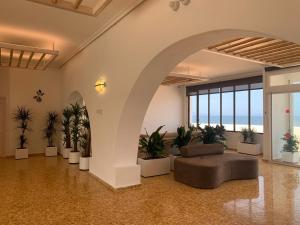 a living room with a couch and some plants at Hotel Roca Bella in Es Pujols