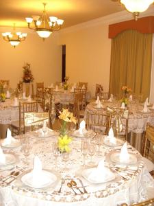 a banquet hall with white tables and chairs with glasses at Gran Real Yucatan in Mérida