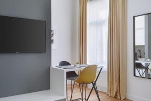 a living room with a desk and a tv on a wall at THE City Lodge - Boutique Apartments in Zagreb