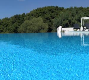 basen z błękitną wodą z dwoma krzesłami w obiekcie Galinio Boutique Apartments w mieście Skafidia