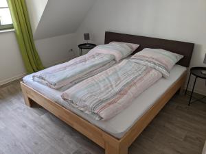 Una cama con dos almohadas encima. en Gut schlafen in der Innenstadt von Zittau - Ferienwohnungen IO19, en Zittau