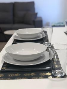 una mesa con platos y vasos en una mesa en Huellas Albergue-Turístico, en Portomarín