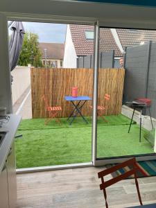 a view of a patio with a table and chairs at Maisonnette de la mer in Hermanville-sur-Mer