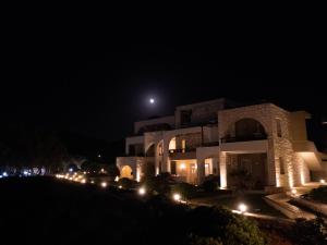 a large building at night with the moon in the sky at Kavos Hotel & Suites in Stavros