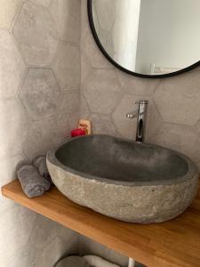 a bathroom with a large stone tub on a wooden shelf at L'annexe in Compiègne