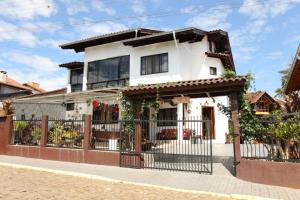 una casa bianca con una recinzione in ferro battuto di SCHUCH - POUSADA a Treze Tílias