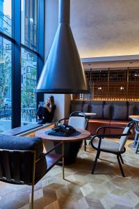 une femme assise dans une pièce avec une table et des chaises dans l'établissement THE TOURIST HOTEL & Cafe AKIHABARA, à Tokyo