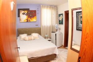 una camera da letto con un letto con lenzuola e cuscini bianchi di SCHUCH - POUSADA a Treze Tílias Altre 11 foto