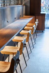 a row of wooden tables and chairs in a restaurant at THE TOURIST HOTEL & Cafe AKIHABARA in Tokyo