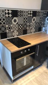 a kitchen with a stove and a counter with tiles at L'Atelier Cosy in Beauvais