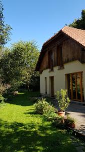 Pilisszentlászló的住宿－Erdőszéli Vendégház，一座房子,旁边是草地庭院