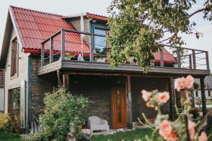 ein Haus mit einem roten Dach und einem Balkon in der Unterkunft Lilia in Engure