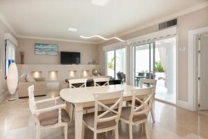 a dining room and living room with a table and chairs at Villa 82 in Corralejo