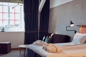 um quarto de hotel com uma cama, uma mesa e uma janela em Nääs Fabriker Hotell & Restaurang em Tollered