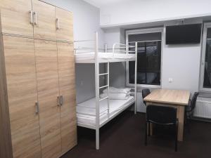 a room with a desk and a bunk bed and a table at Hostel Anilux in Jelenia Góra