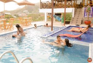 a group of people in a swimming pool at Hostal Casa Roma in Taganga