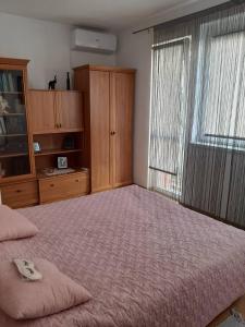 a bedroom with a large bed and a large window at Apartman Maja in Bijeljina