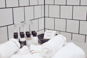 um balcão de casa de banho com garrafas de sabão e um lavatório em Nääs Fabriker Hotell & Restaurang em Tollered
