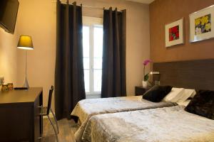 Voodi või voodid majutusasutuse Hotel des Arceaux toas