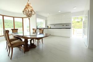 a kitchen with a dining room table and chairs at Villa Paradise , playa privada a 10 minutos de Sitges in Sant Pere de Ribes