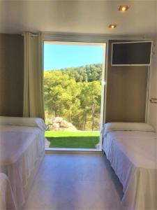 two beds in a room with a large window at Villa Paradise , playa privada a 10 minutos de Sitges in Sant Pere de Ribes +58 photos