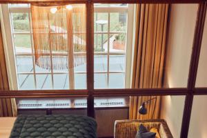 um quarto com uma janela com uma cadeira e uma mesa em Nääs Fabriker Hotell & Restaurang em Tollered