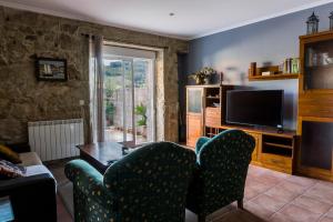 a living room with two chairs and a television at Chalet en Canido in Vigo