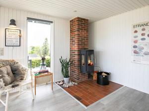 sala de estar con chimenea de ladrillo y sofá en 6 person holiday home in Brenderup Fyn, en Vedelshave