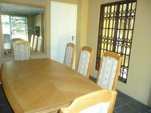 a dining room table and chairs with a wooden table at Royal Guest House in East London