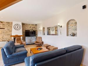 sala de estar con sofá azul y sillas en Countryside holiday home with pool en Renaison
