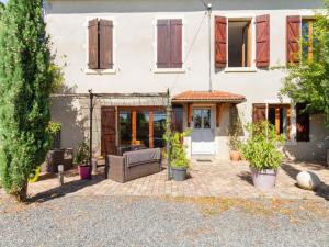 a house with a patio with a couch at Countryside holiday home with pool in Renaison