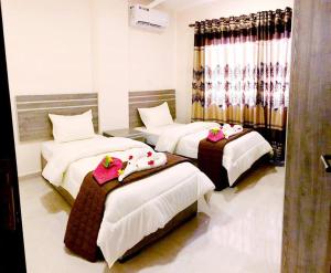 a hotel room with three beds with dolls on them at RAWA'AT ALAQABA in Aqaba