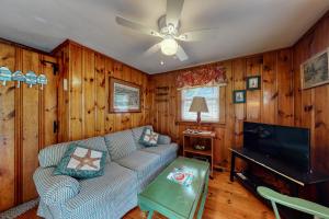 ein Wohnzimmer mit einem Sofa und einem Flachbild-TV in der Unterkunft Otis Cottages in York