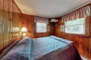 - une chambre avec un lit dans une pièce dotée de murs en bois dans l'établissement Otis Cottages, à York