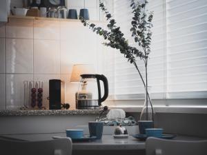 a table with a vase of flowers in a kitchen at B&B Het Ruime Sop in Wassenaar