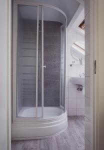 a shower with a glass door in a bathroom at B&B Het Ruime Sop in Wassenaar